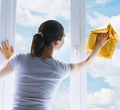 Woman cleaning window with a cleaning cloth